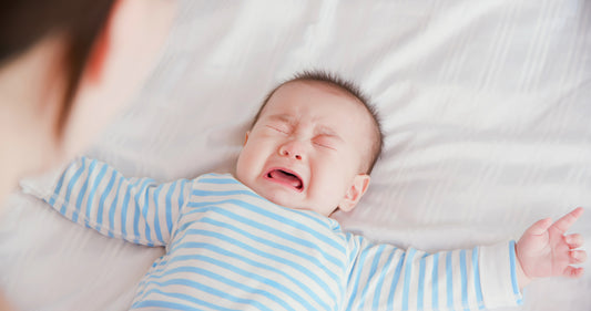 Baby crying on bed